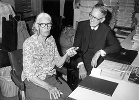 woman with white hair and glasses sitting with man with glasses