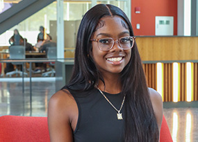 female student sitting in chair in Higgins