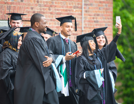 female students taking selfie photo at graduation ceremony