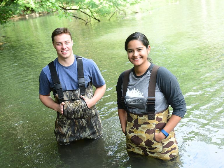 two students in lake doing research for Environmental Engineering