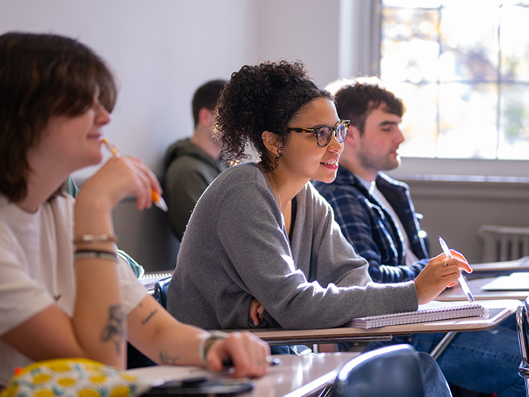 Student takes notes during a lively lecture.