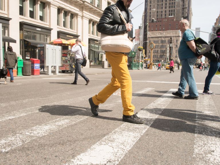 woman on busy street wearing yellow pants