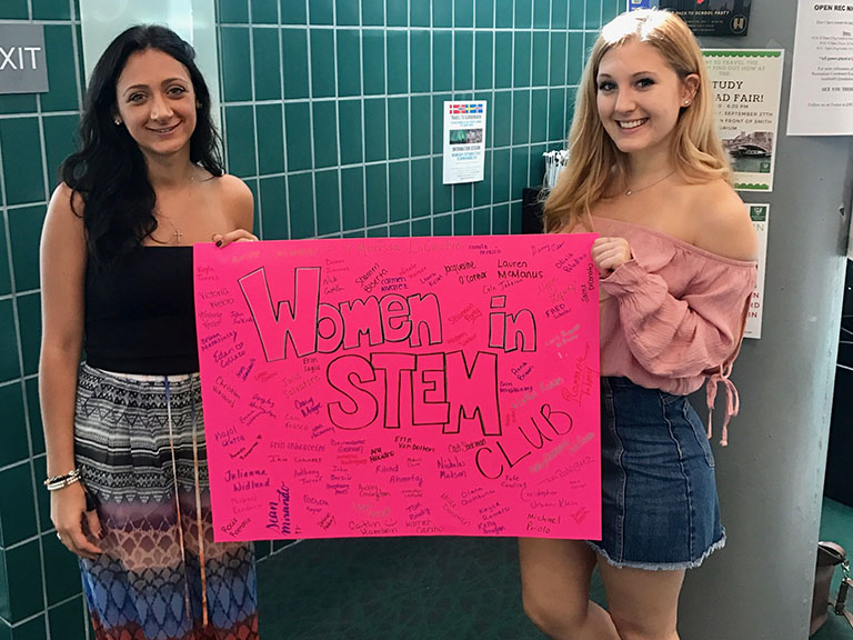 Students holding Women in STEM poster.