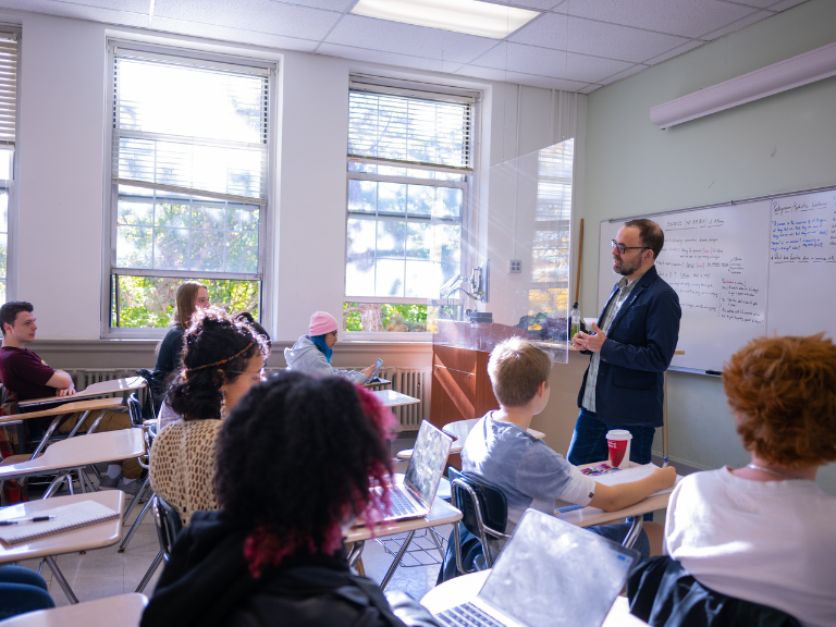 professor bollert teaching manhattan college students in a classroom