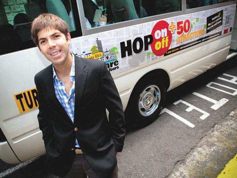 Andres Oreamuno '14 stands in front of City Square Tours bus.
