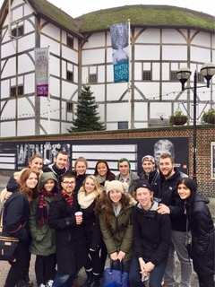 students pose in front of the Globe Theater in London