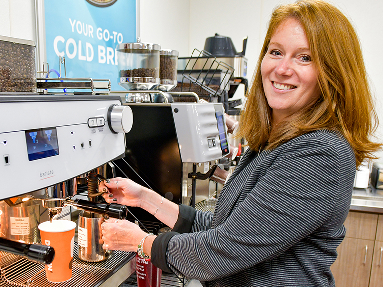 Katy Latimer operating an espresso machine.
