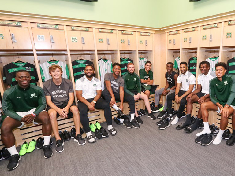 Men's soccer players sitting at lockers in Gaelic Park Athletic Center