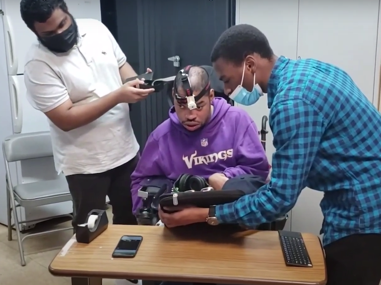 Students assisting individual with headband scanner