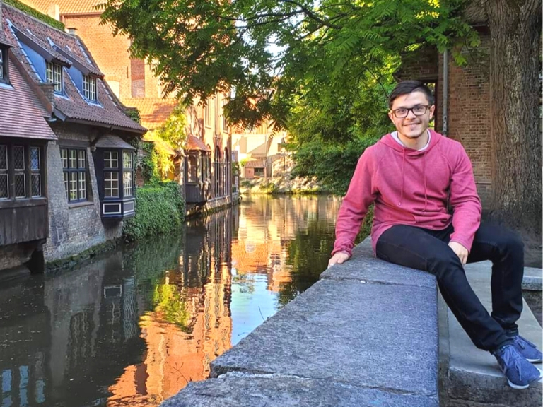 Miguel Diaz-Lopez sitting next to a river in europe.