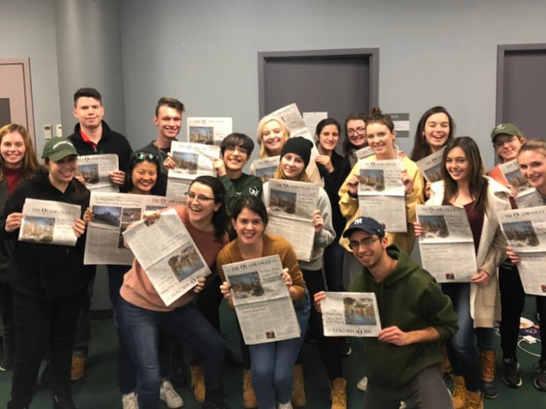 members of student newspaper the quad holding up newspapers