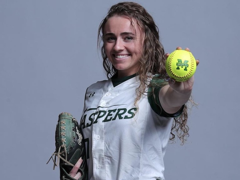 Jessie Rising posing with a Jaspers-branded softball.