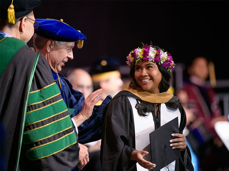 Photo of female student being hooded by Dean Donald Gibson