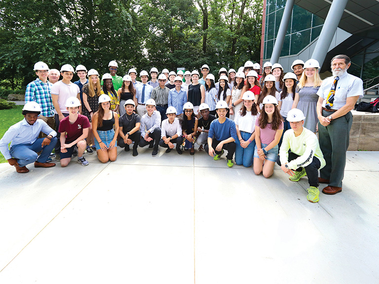 Image of Walter Saukin, Ph.D. and engineering students standing together on campus.