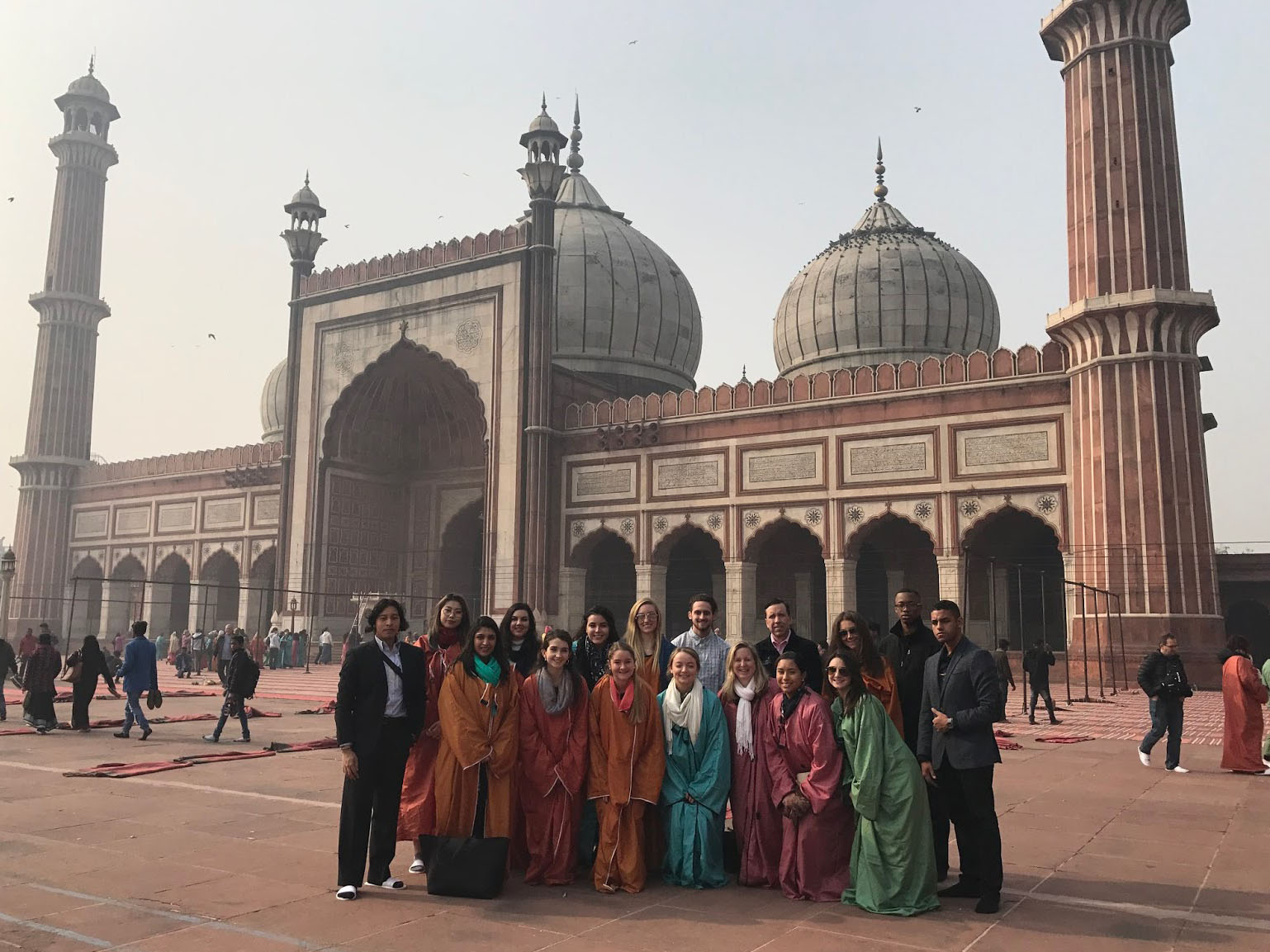 business cohort stands in front of indian mosque