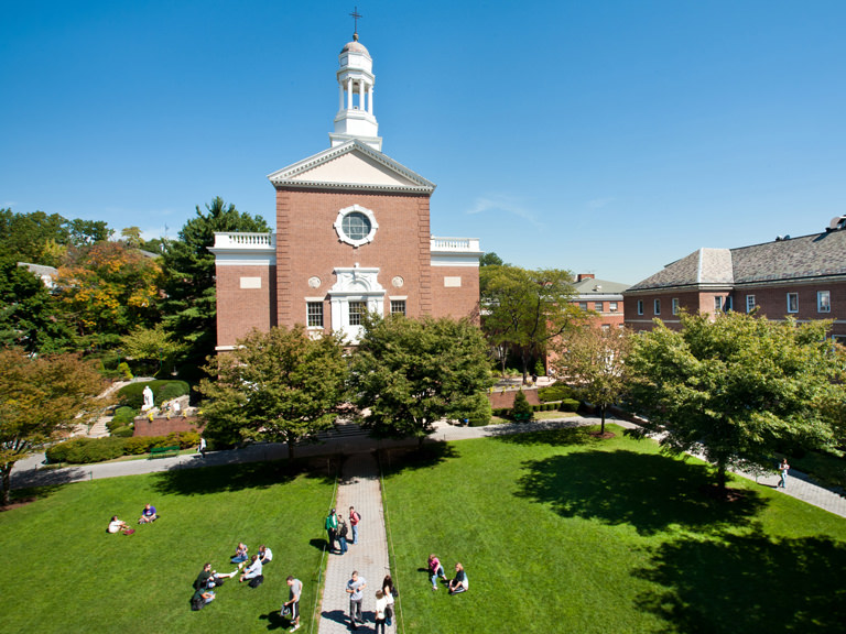 a group of four students walking on the quad