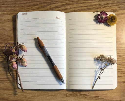 notebook surrounded with flowers