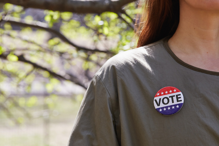 close up of young woman wearing vote button